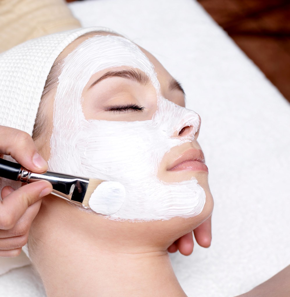 Aplicación de mascarilla facial con brocha en un spa